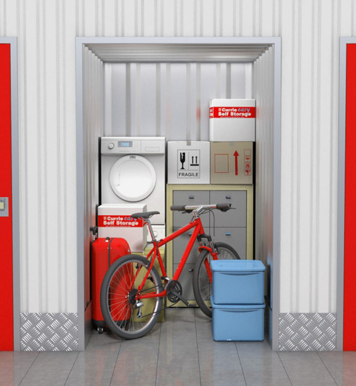 A bike, suitcase, washing machine and boxes are stored in a storage room.