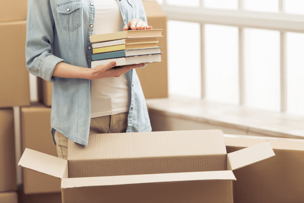 person storing books in box