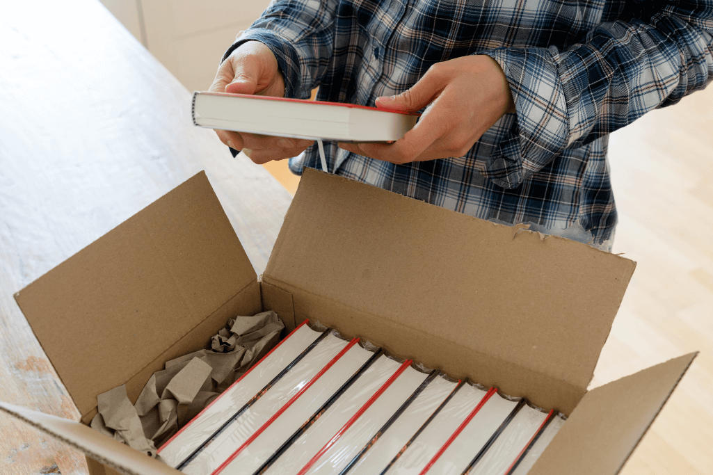 person filling box of books