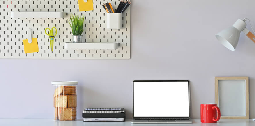 Image of home office desk space 
with peg board on the wall. 
