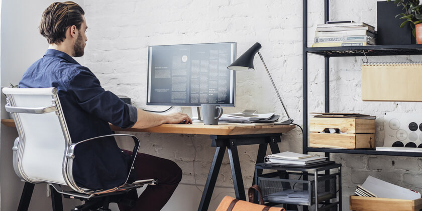 Image of a man working in a tidy home office. 