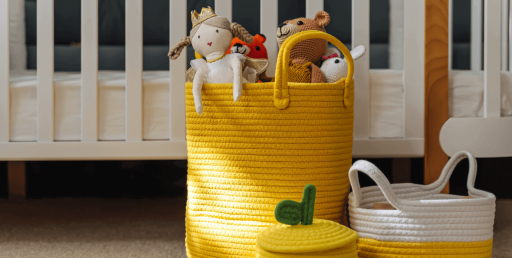 Three yellow storage baskets containing cuddly toys.
