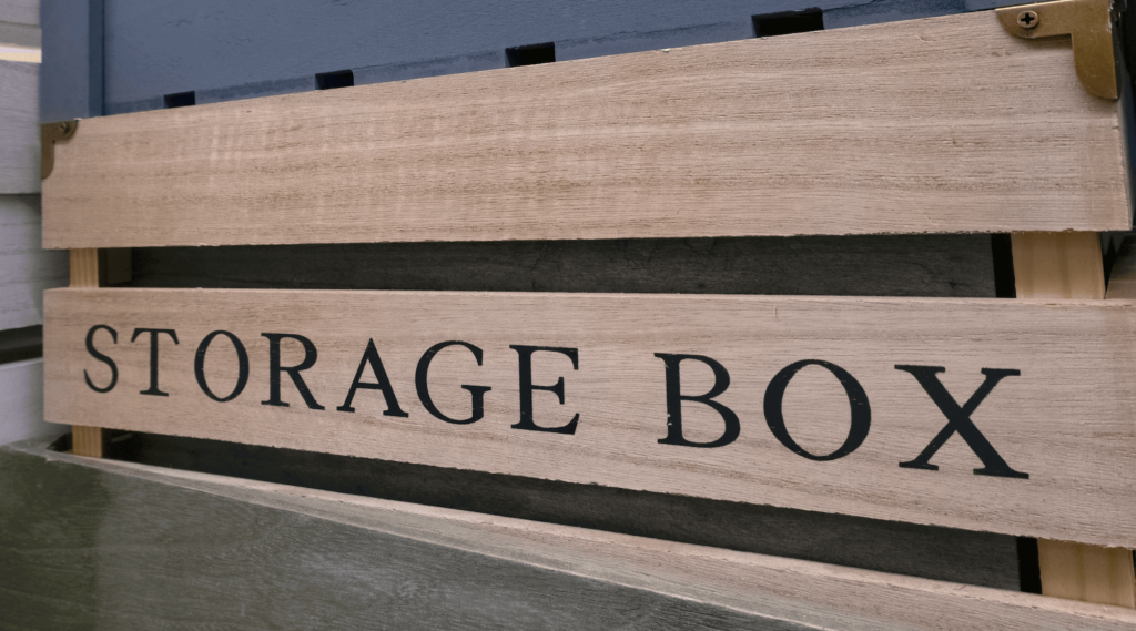 A wooden crate with the words 'STORAGE BOX' printed on the front.