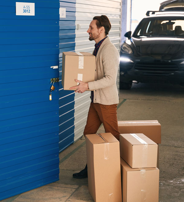 young-man-carrying-box-in-self-storage-unit