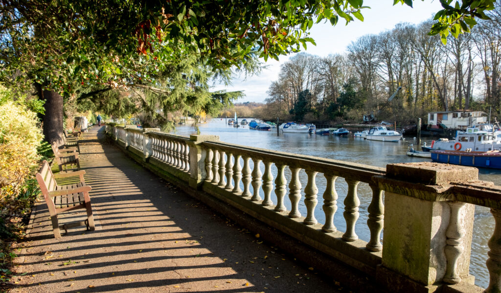 An image of a bridge over water and benches along the path.